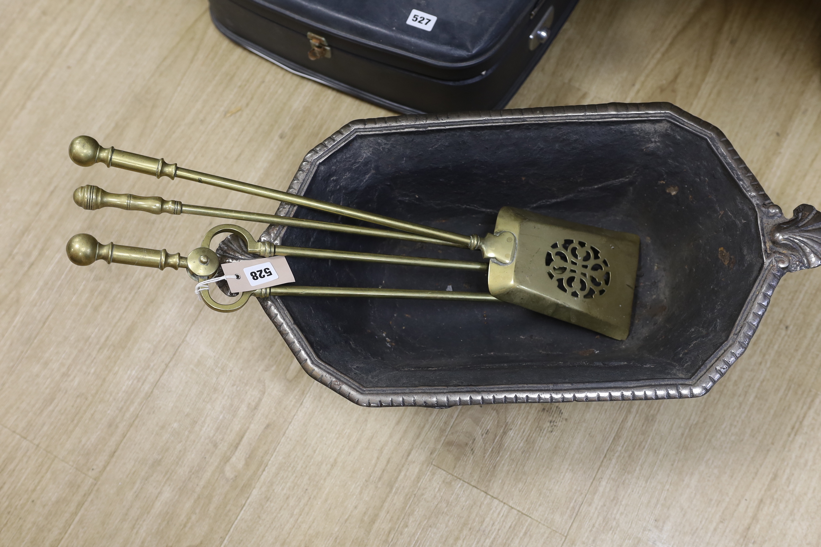 A cast iron log box and set of three brass fire-irons